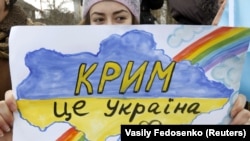 Девушка держит рисунок во время митинга в Крыму, 10 марта 2014 года