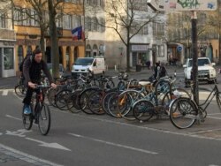 Велосипедист и припаркованные велосипеды на улице в центре Страсбурга